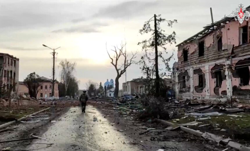 A Russian service member walks past destroyed buildings in Sudzha - برفيلكس - brieflex كورسك تحت الحصار.. معركة جديدة تعيد إشعال الصراع بين موسكو وكييف - برفيلكس - brieflex