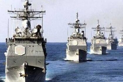 Line of gray military ships sailing in formation across the ocean (Reuters photo).