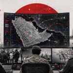 Military command center monitoring a large digital map with red target markers while officers sit at consoles overlooking ships and aircraft in a port.
