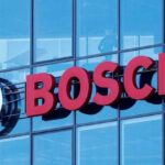 Bosch logo on a blue glass office building, with the circular emblem to the left of red 'BOSCH' lettering. (Brand sign) - برفيلكس - brieflex