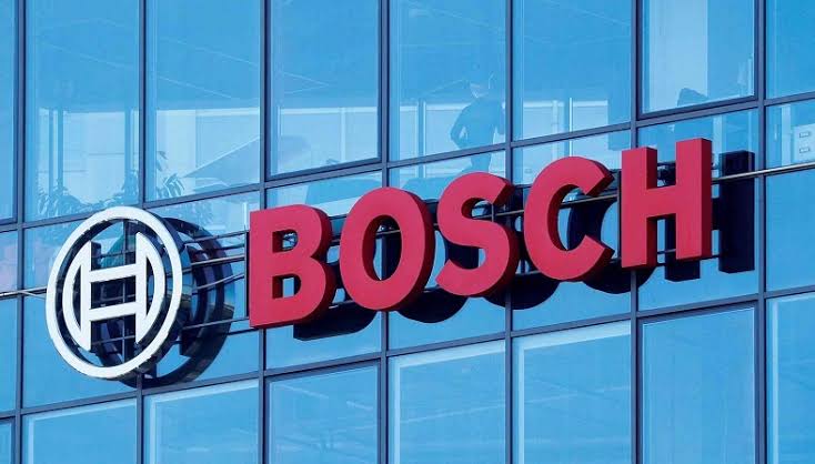 Bosch logo on a blue glass office building, with the circular emblem to the left of red 'BOSCH' lettering. (Brand sign) - برفيلكس - brieflex