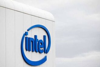 Intel logo displayed on the side of a white building against a cloudy sky