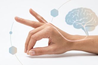 Outstretched hand with a glowing curved line linking to a brain illustration, symbolizing neural connection and touch.
